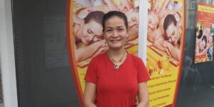 Die freundliche Thailänderin Kitty in einem roten T-Shirt in ihrem Stuttgarter Thai Massage Salon.